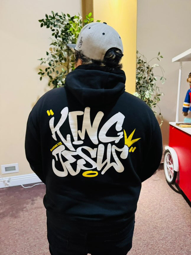 Filipino man showcasing the back design of the King Jesus Hoodie from a side angle in full color—bold Christian streetwear with a faith-inspired message.